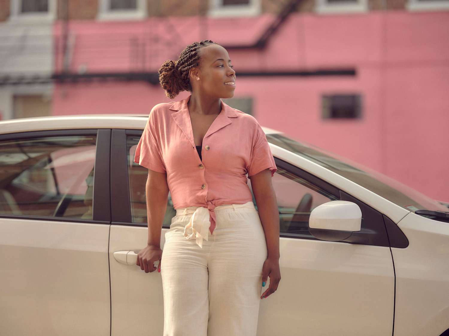 A Lyft driver standing outside of her car.